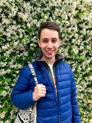 PA Student Christian Munoz-Pineda in front of flowering bush